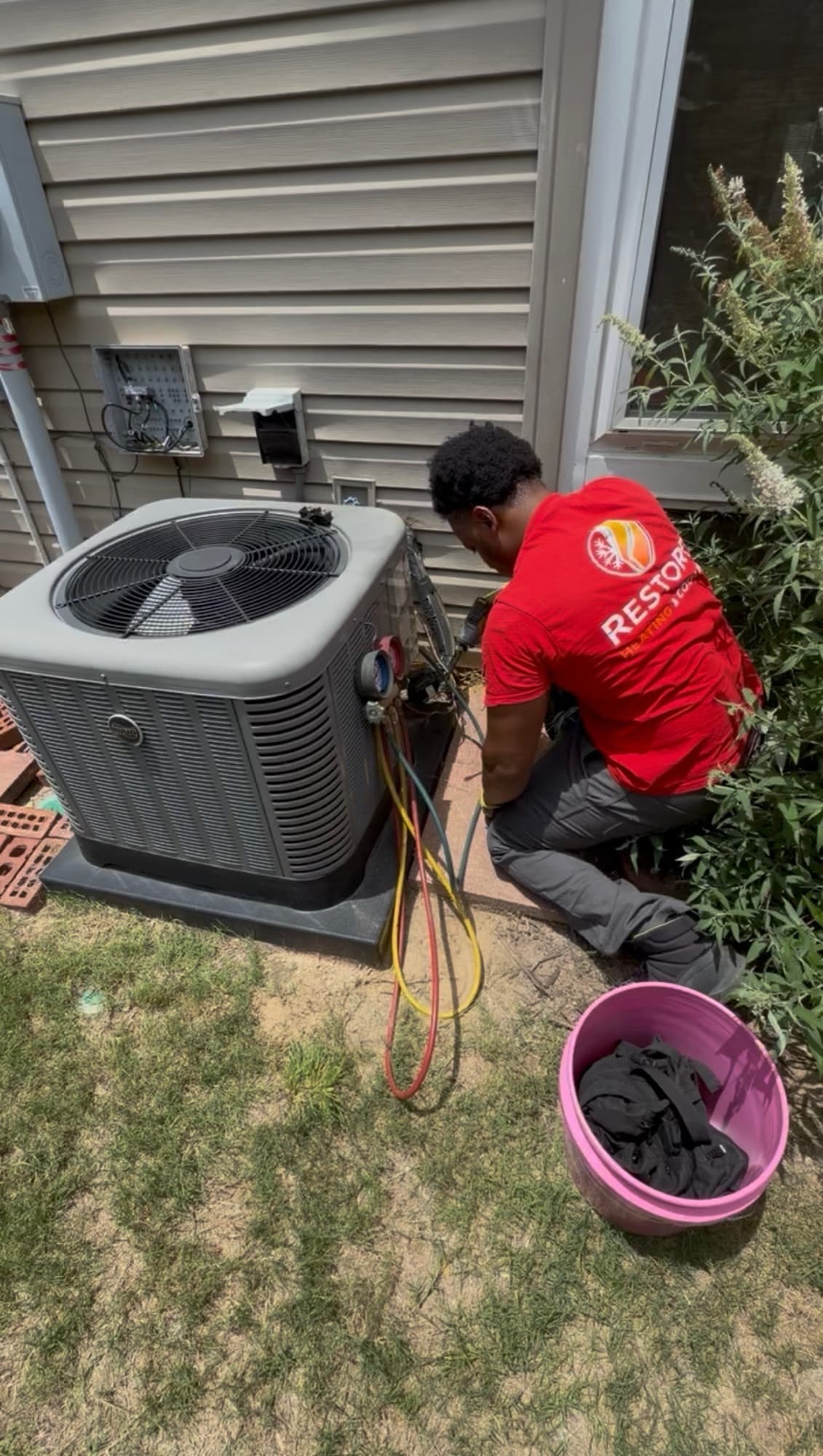 Restore technician using manifold gauges during a residential HVAC diagnostic